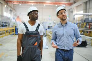 An engineer communicates with a worker on a production line photo