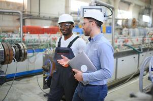 Two workers at a factory for the production of plastic windows. Engineer and worker on the production line photo
