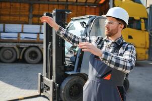 Man worker at forklift driver happy working in industry factory logistic ship photo