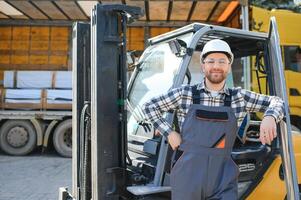 Man worker at forklift driver happy working in industry factory logistic ship photo