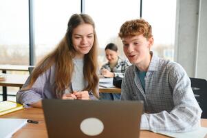 Group of college students using laptop in the library photo