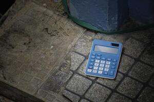 Blue calculator on old concrete background photo
