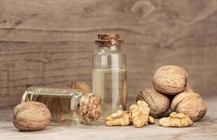 Walnut oil still life. Glass bottle nut oil on rustic wooden table photo