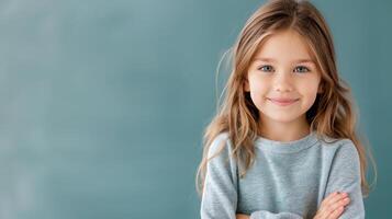 Young Girl Smiling With Arms Crossed Against Gray Background photo