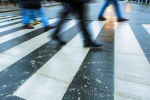 Many people on a zebra crossing a road with motion blur of a long time exposure. AI generate photo