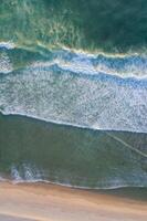 waves on the shore of a deserted beach, aerial view from a drone. Aerial top view from UAV drone photo