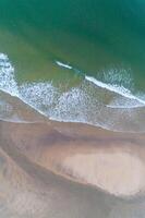 waves crashing on the beach in summer, aerial top view from drone. Holidays concept photo