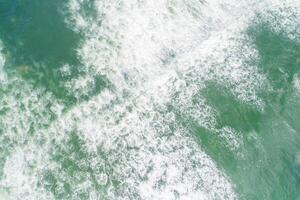 foam of the waves on the shore. Aerial top view from drone. Textured background photo