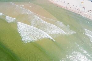 aerial zenithal view from a drone of the shore of a beach in summer, with turquoise sea water. photo