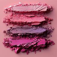 Crushed pink and purple eyeshadow hues arranged on a pink background, showcasing vibrant colors and textures perfect for beauty and makeup themes. photo
