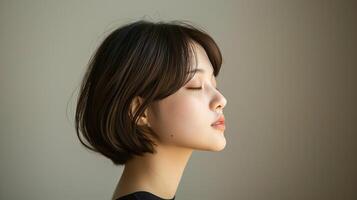 Side profile of a woman with short hair and closed eyes, exuding a sense of tranquility and calmness in soft lighting. photo