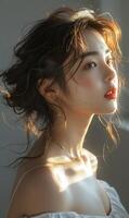 A close-up portrait of an elegant woman with wavy hair, illuminated by natural light, showcasing her glowing skin and red lips. photo