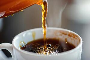 Coffee extract being poured into a cup of coffee. photo