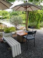 Small wooden table and chair with the whte umbrella. photo