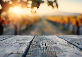 Glass of Red Wine Next to Grapes on Wooden Table at Sunset in Vineyard photo