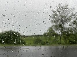Raindrops on a Windowpane, Blurred Trees in the Background photo