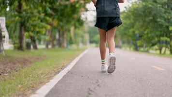 A young girl is running on a road with a pair of white sneakers photo