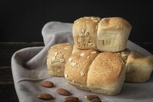 three rolls of bread with almonds on a napkin photo