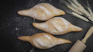 three buns with flour and wheat on a black background photo