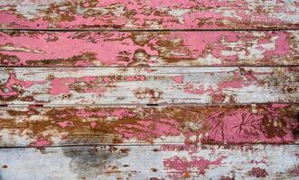 Full frame background of an old and faded wood board wall painted in red photo