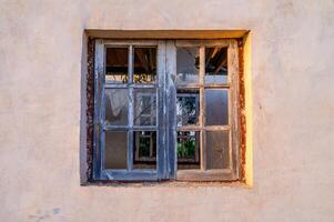 Old broken window on an abandoned old building photo
