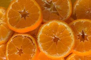 Fresh, juicy tangerine slices or tangerines with leaves as a background 1 photo