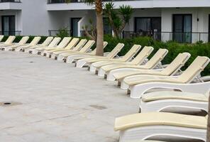 Towels on sunbeds around swimming pool photo