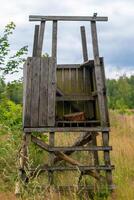 wooden hunting structure with a ladder and a bench photo