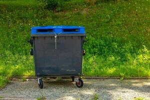 blue trash can is empty and has a chain on it photo