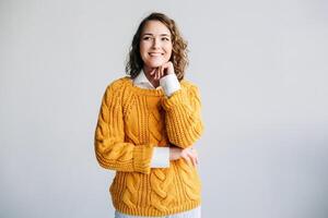 Young Woman Student Contemplates Future - Dreamy, Smiling, Hand on Chin - Reflecting on Ideas and Opportunities - Isolated on White Background - Conceptual Image of Hope and Aspiration for Success. photo