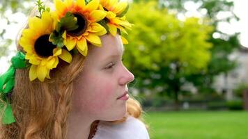 Sunflowers Red-haired girl with a wreath on her head. beautiful girl with a wreath on her head looks at the camera video
