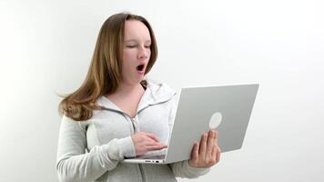 Tired elementary student yawning using laptop during homeschooling. Cute kid studying hard, asleep lazy school girl yawn, boring sleepy unhappy girl sitting at desk doing homework video