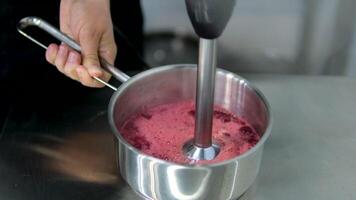Blend Cherry Sauce for meat. close-up of cherry sauce boiling in small saucepan in a professional kitchen video