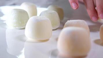Photos of motti of different colors with different fillings isolated on background, a delicious colored dessert. video