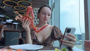 Blog seafood. girl with a huge crab in her hands blogs from a restaurant a blogger talks about her lunch in Asia video