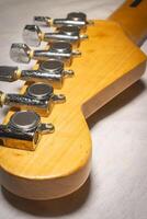 Close up from a Headstock of a guitar made of Maple wood, and some silver color tuners. photo