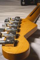 Close up from a Headstock of a guitar made of Maple wood, and some silver color tuners. photo