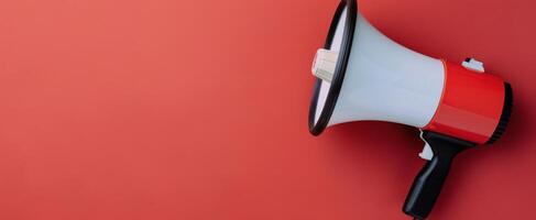 Bright Red Megaphone Positioned Against Solid Red Background photo