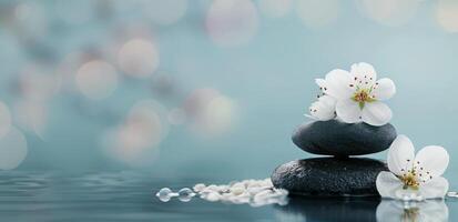 Black Stones Stacked With White Flowers Beside Water in Serene Environment photo