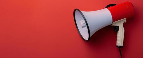 Bright Red Megaphone Positioned Against Solid Red Background photo