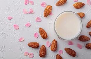Creamy Almond Milk Surrounded by Almonds and Fresh Leaves on a White Background photo
