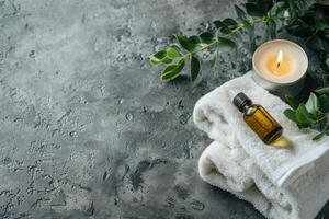 Massage stones, essential oils and candle on a grey background. Beauty items for spa procedure. photo