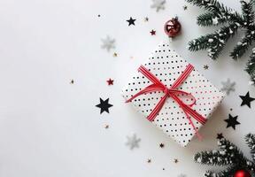 Wrapped Christmas Gift Surrounded by Stars and Evergreen Foliage on White Background photo