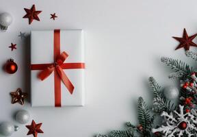 Wrapped Christmas Gift Surrounded by Stars and Evergreen Foliage on White Background photo