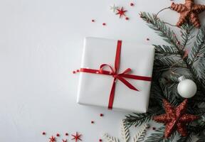 Wrapped Christmas Gift Surrounded by Stars and Evergreen Foliage on White Background photo