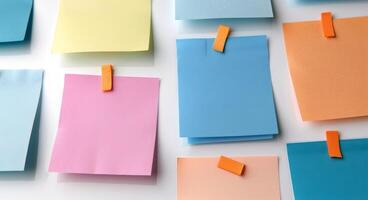 Colorful Sticky Notes Secured With Metal Clips on White Background photo