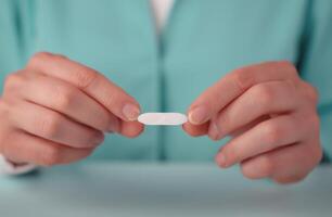 Hands Holding A Small White Tablet In A Lightly Colored Setting photo