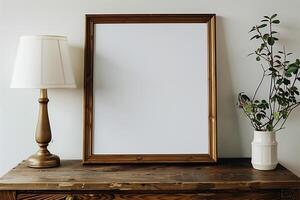 a wooden table with a blank white canvas with wood frame and a lamp photo
