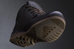 Leather boot on a dark background close-up view from below. Autumn shoes photo