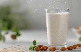 Creamy Almond Milk Surrounded by Almonds and Fresh Leaves on a White Background photo